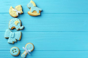 Baby cookies decorated with glaze on wooden background