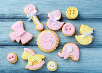 Baby cookies decorated with glaze on wooden background