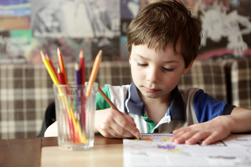 Child drawing with pencils