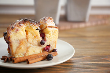 Plate with piece of delicious bread pudding on wooden table