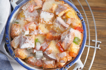 Freshly baked bread pudding in casserole dish on wooden table