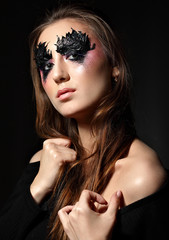 Beautiful Girl posing on black background. Fashion Makeup. Creative Make-up Background.Black background