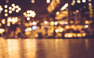 Wood table top with reflect on blur of lighting in cafe,restaurant background/selective focus.