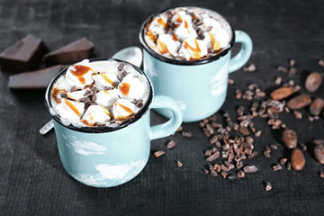 Cups of hot cocoa with marshmallows on table