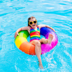 Child with toy ring in swimming pool