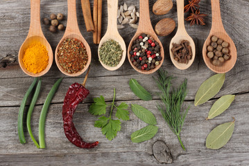 herbs and spices, onion, garlic and chili pepper on old wood background