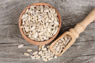 Sunflower seeds in bowl on old wooden table