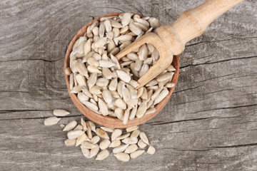 Sunflower seeds in bowl on old wooden table