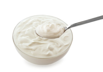 Bowl of tasty yogurt and spoon on white background