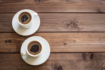 View of the two cup of coffee on the wooden table with place for inscription