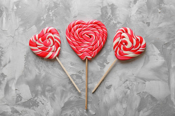 Tasty lollipops on grey textured background