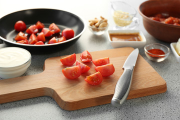 Cutting tomatoes on wooden board