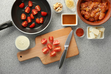 Cutting tomatoes on wooden board
