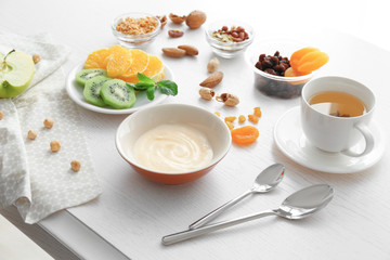 Composition with tasty yogurt on kitchen table