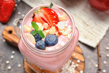Delicious parfait with fruits in jar on table