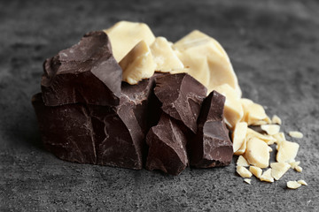 Chunks of dark and white chocolate on grey background