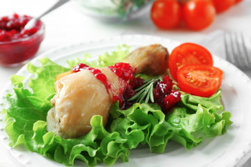 Portion of chicken and cranberry sauce on plate