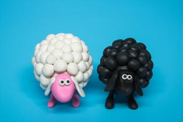 Concept - A black and a white polymer clay sheep placed next to each other