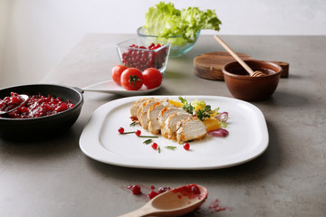 Portion of chicken and cranberry sauce on table