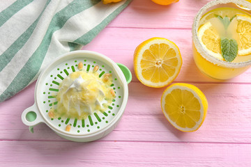 Squeezer and lemons on wooden table