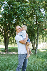 Fototapeta premium Happy loving family. father and child girl playing, kissing and hugging outdoor in park