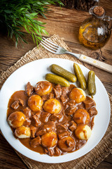 Stew served with silesian noodles and sauce.