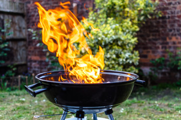 Flames rise from a barbeque grill 