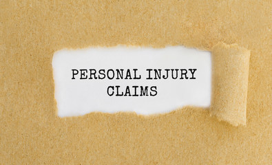 Text Personal Injury Claims appearing behind ripped brown paper