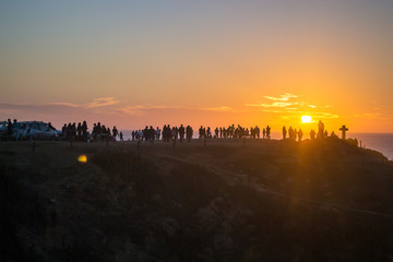 Orange sunset at the beach with silhouette of people in Pichilemu, Chile.