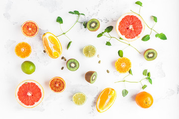 Colorful fresh fruit on white table. Orange, tangerine, lime, kiwi, grapefruit. Fruit pattern. Summer food concept. Flat lay, top view