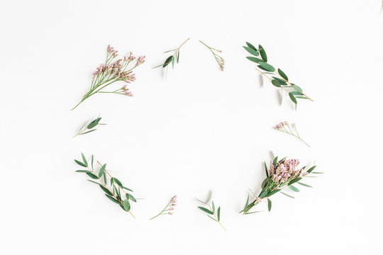 Flowers composition. Frame made of pink flowers and eucalyptus branches on white background. Flat lay, top view