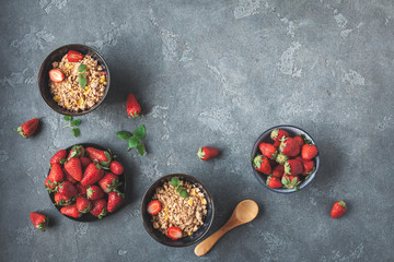 Obraz na płótnie Canvas Breakfast with muesli, fresh strawberry on black background. Healthy food concept. Flat lay, top view