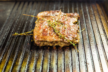 Grilled beef steak on the grill, close-up.
