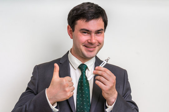 Businessman in suit is smoking an electronic cigarette