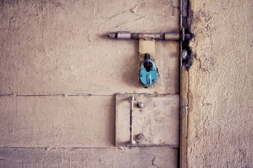 Old blue metallic door lock on the background of concrete wall. Security concept.