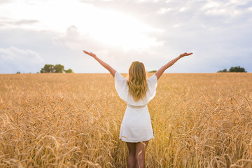 woman walking in the wheat- concept about nature, agriculture and people.