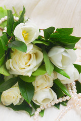 white fresh rose and tulips flowers bouquet close up on white lace background