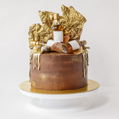 Men's chocolate cake, decorated with gilded chocolate and bottles of whiskey.