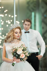 Beautiful young newlyweds in wedding dresses in a modern interior