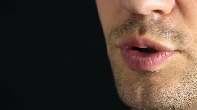 A person whisper into the camera. Close-up of the lips. whisper On a black background