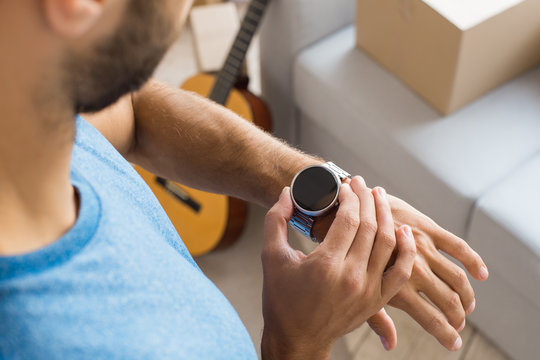 Young Man Checking Time On Watch Planning Relocation