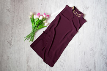 Purple blouse, bouquet of tulips. Fashionable concept, wooden background