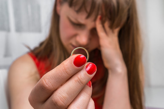 Woman is holding wedding ring - divorce concept