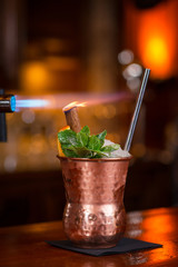 Cocktail. Mint Julep with orange in copper glass and steel straw