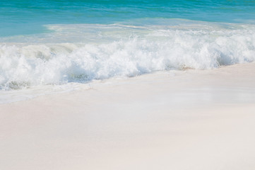 Fototapeta na wymiar Turquoise sea with white waves and white sand.