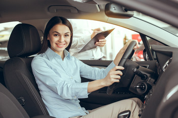 Fototapeta na wymiar Young Woman in a Car Rental Service Test Drive Concept