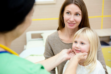 Obraz na płótnie Canvas Beautiful woman and her cute little daughter visiting pediatrician