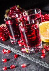 Fresh red juice cocktail with pomegranate seeds and ice