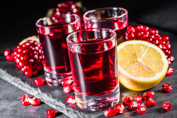 Fresh red juice cocktail with pomegranate seeds and ice