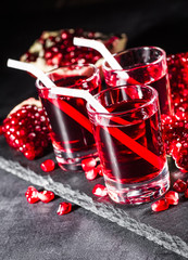 Fresh red juice cocktail with pomegranate seeds and ice